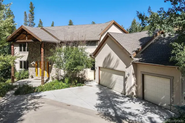 a view of a house with a yard and large tree