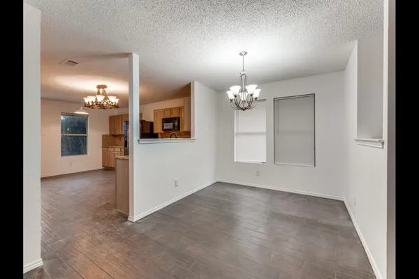 an empty room with chandelier and glass door
