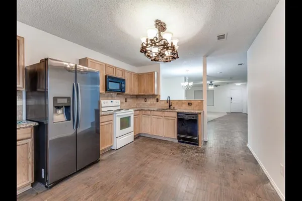 a large kitchen with a refrigerator and a stove top oven