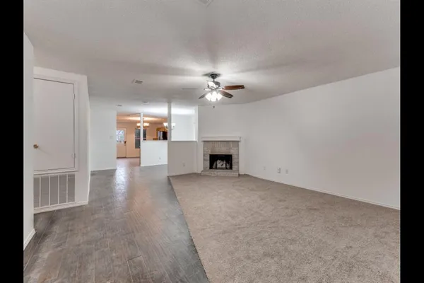 a view of a livingroom with a fireplace and chandelier fan