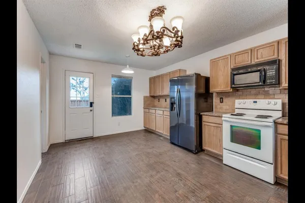 a kitchen with stainless steel appliances kitchen island granite countertop a refrigerator stove and sink