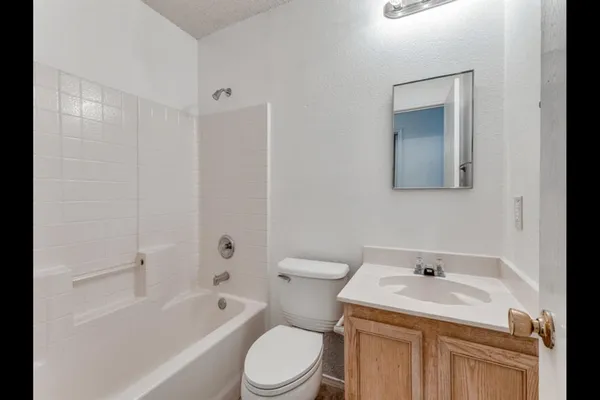 a bathroom with a sink toilet vanity and bathtub