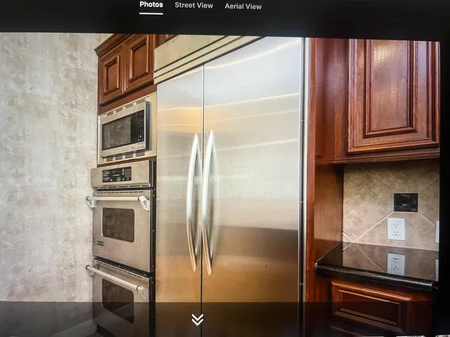 a kitchen with kitchen island granite countertop a sink stove and cabinets