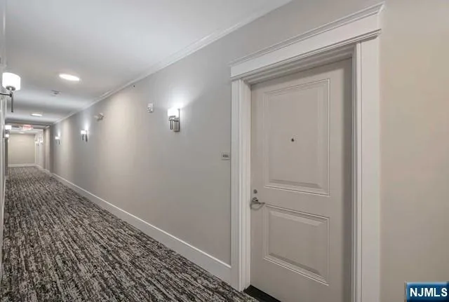 a view of an empty room with wooden floor and closet