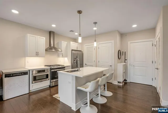 a kitchen with stainless steel appliances granite countertop a stove a refrigerator and a microwave