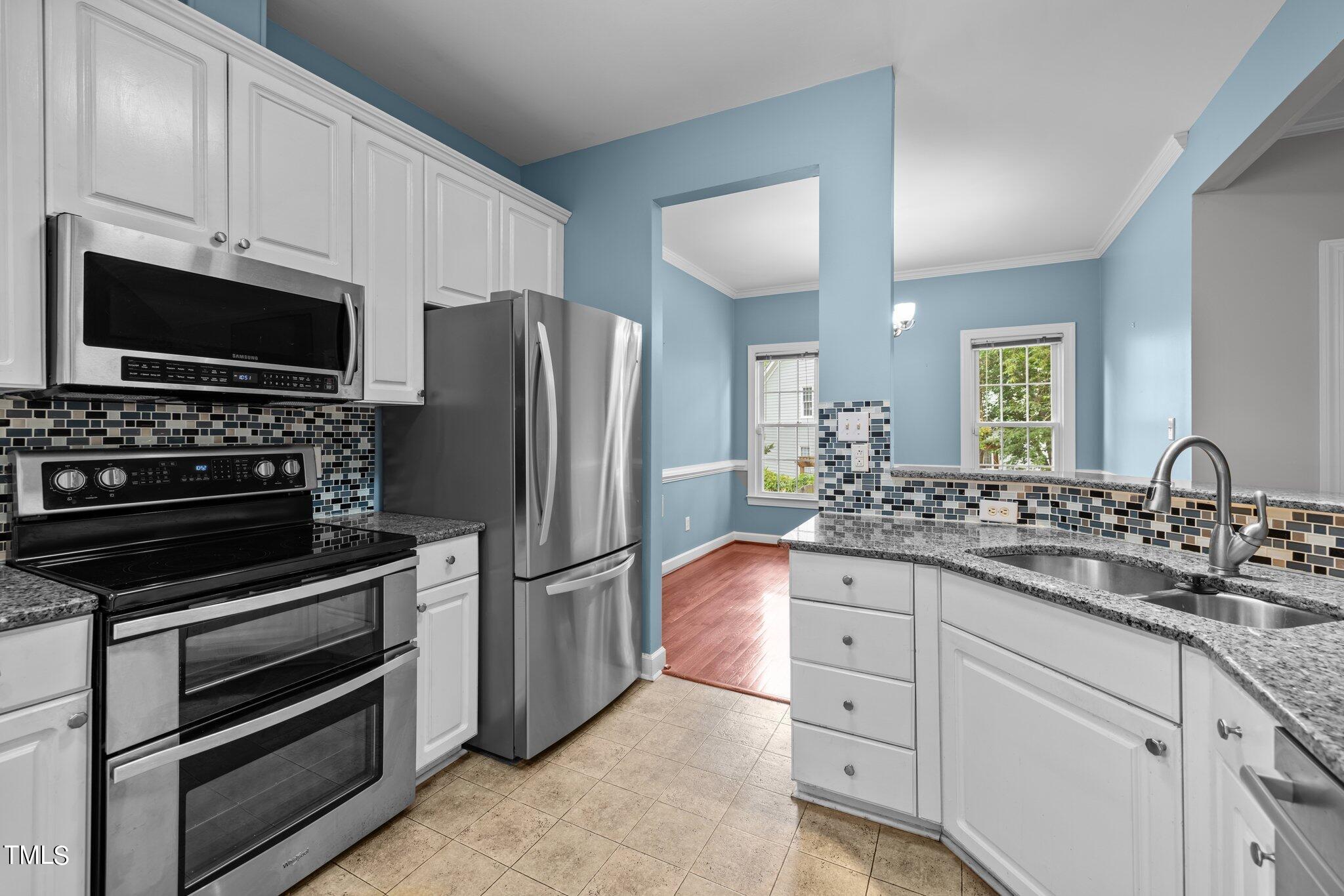 5105 Six Point Trail Raleigh, NC 27616 - Photo 7 of 39 a kitchen with granite countertop a refrigerator stove and microwave