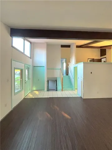 a view of a room with wooden floor and a window