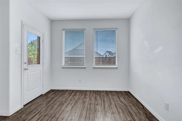 a kitchen with stainless steel appliances granite countertop a stove top oven a sink dishwasher and a refrigerator with wooden floor