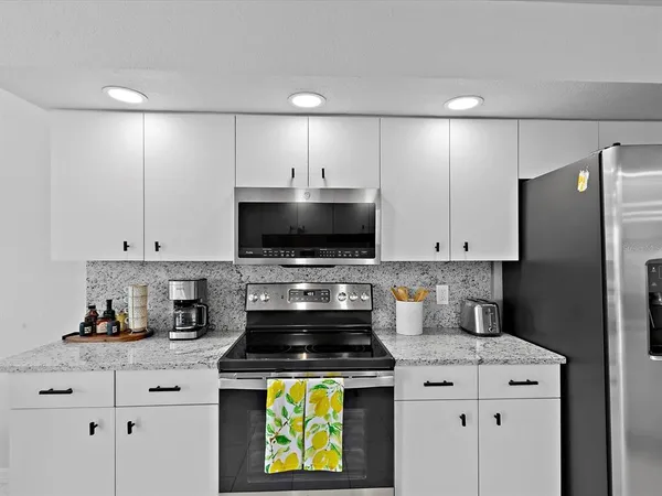 a kitchen with appliances a sink and cabinets