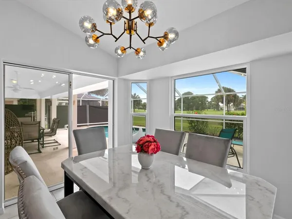a dining room with furniture large windows and wooden floor