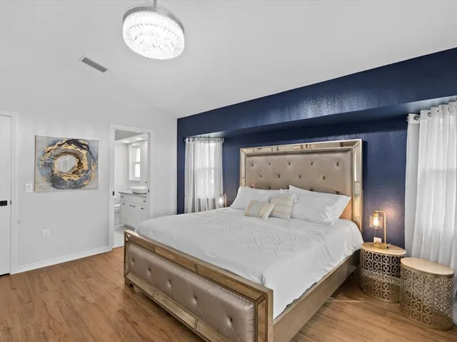 a bedroom with a bed and a chandelier