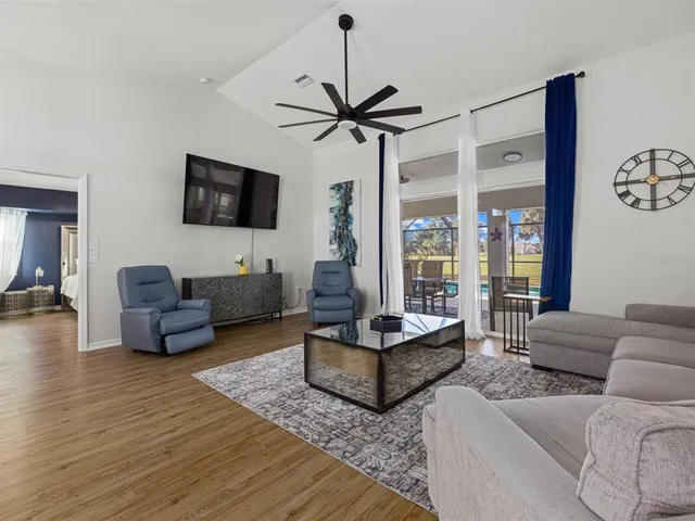 a living room with furniture a flat screen tv and a large window