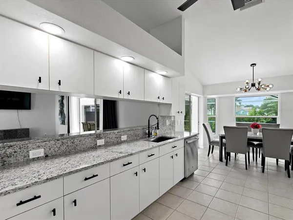 a large kitchen with kitchen island granite countertop a table and chairs