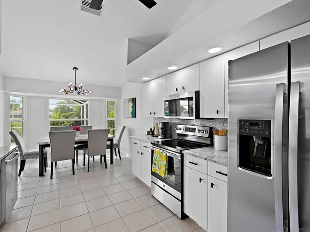 a kitchen with stainless steel appliances granite countertop a refrigerator and a stove top oven