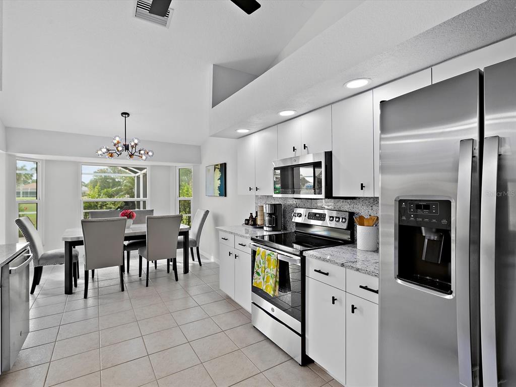 39 Long Meadow Court Rotonda West, FL 33947 - Photo 10 of 30 a kitchen with stainless steel appliances granite countertop a refrigerator and a stove top oven