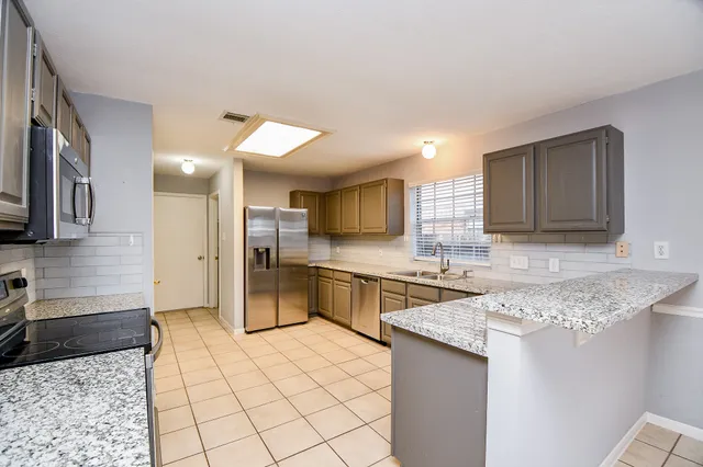 a kitchen with white cabinets sink and window