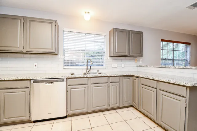 a kitchen with stainless steel appliances granite countertop a sink and dishwasher a stove top oven with wooden floor
