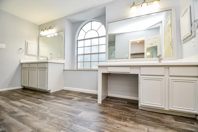 a spacious bathroom with a double vanity sink a mirror and a shower