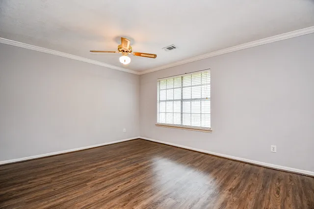 a view of empty room with wooden floor