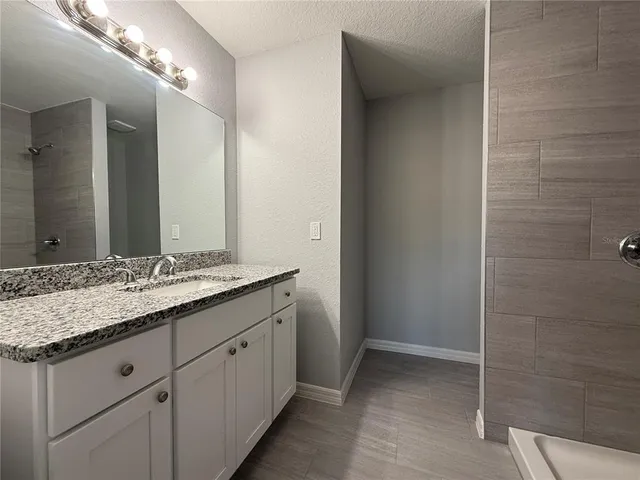 a bathroom with a granite countertop sink and a mirror