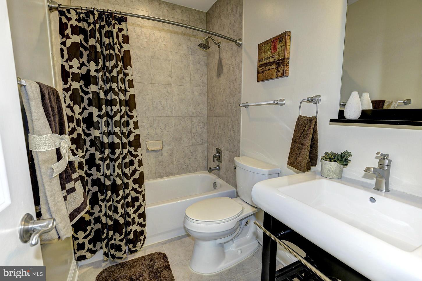 1925 North Capitol Street Northeast, Unit 2 Washington, DC 20002 - Photo 19 of 22 a bathroom with a sink toilet a shower and a mirror