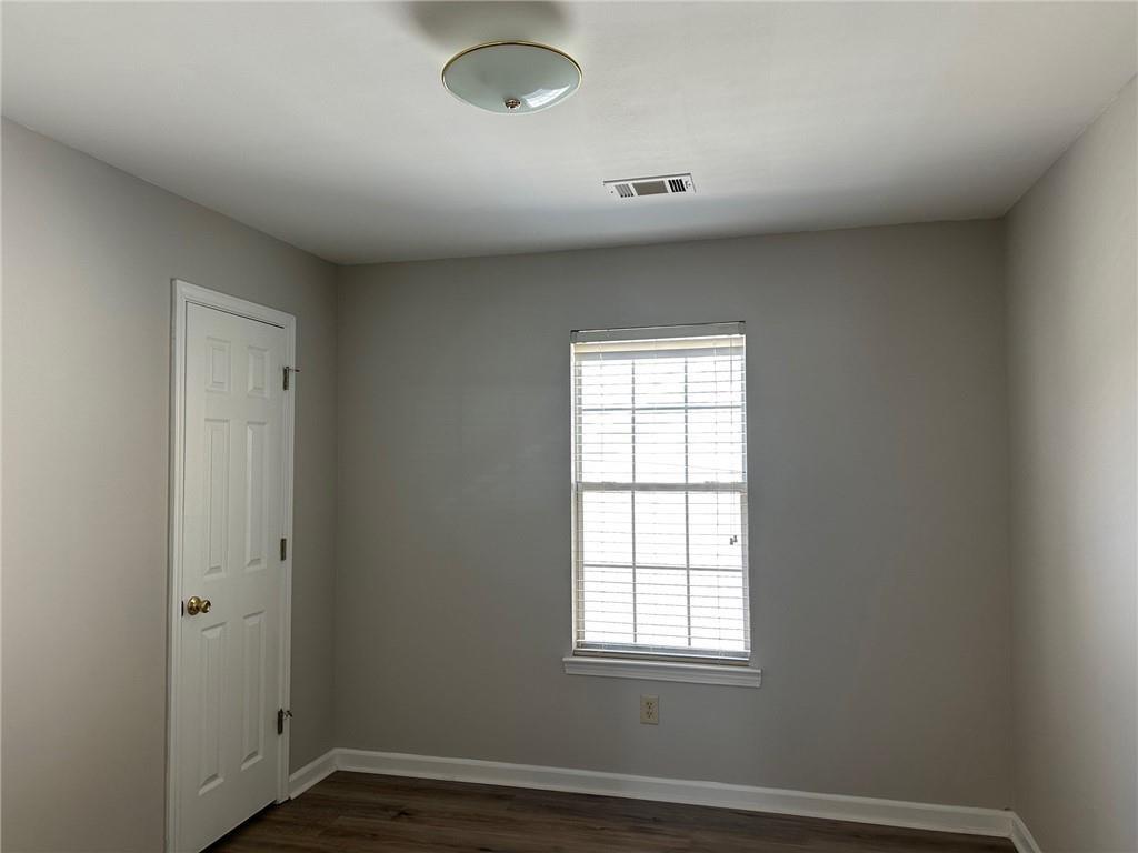 6770 Biscayne Rex, GA 30273 - Photo 14 of 24 an empty room with wooden floor and windows