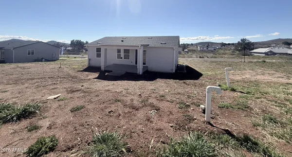 a view of a dry yard with wooden fence