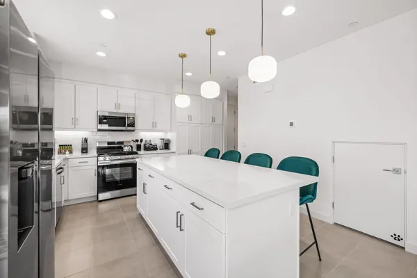 a kitchen with cabinets appliances a sink and a window