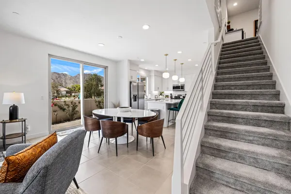 a kitchen with stainless steel appliances kitchen island granite countertop a stove a sink a dining table and chairs