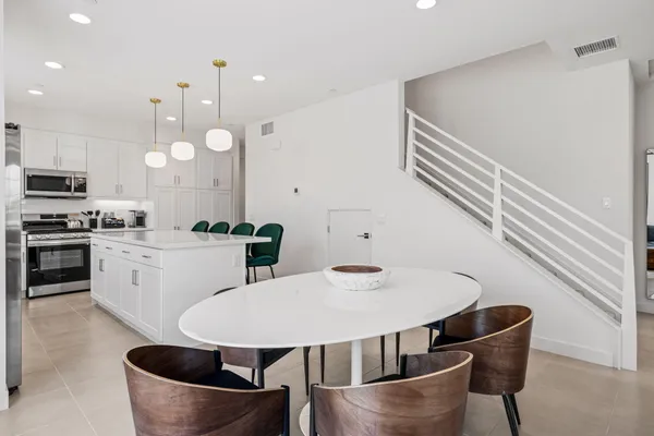 a kitchen with white cabinets and stainless steel appliances