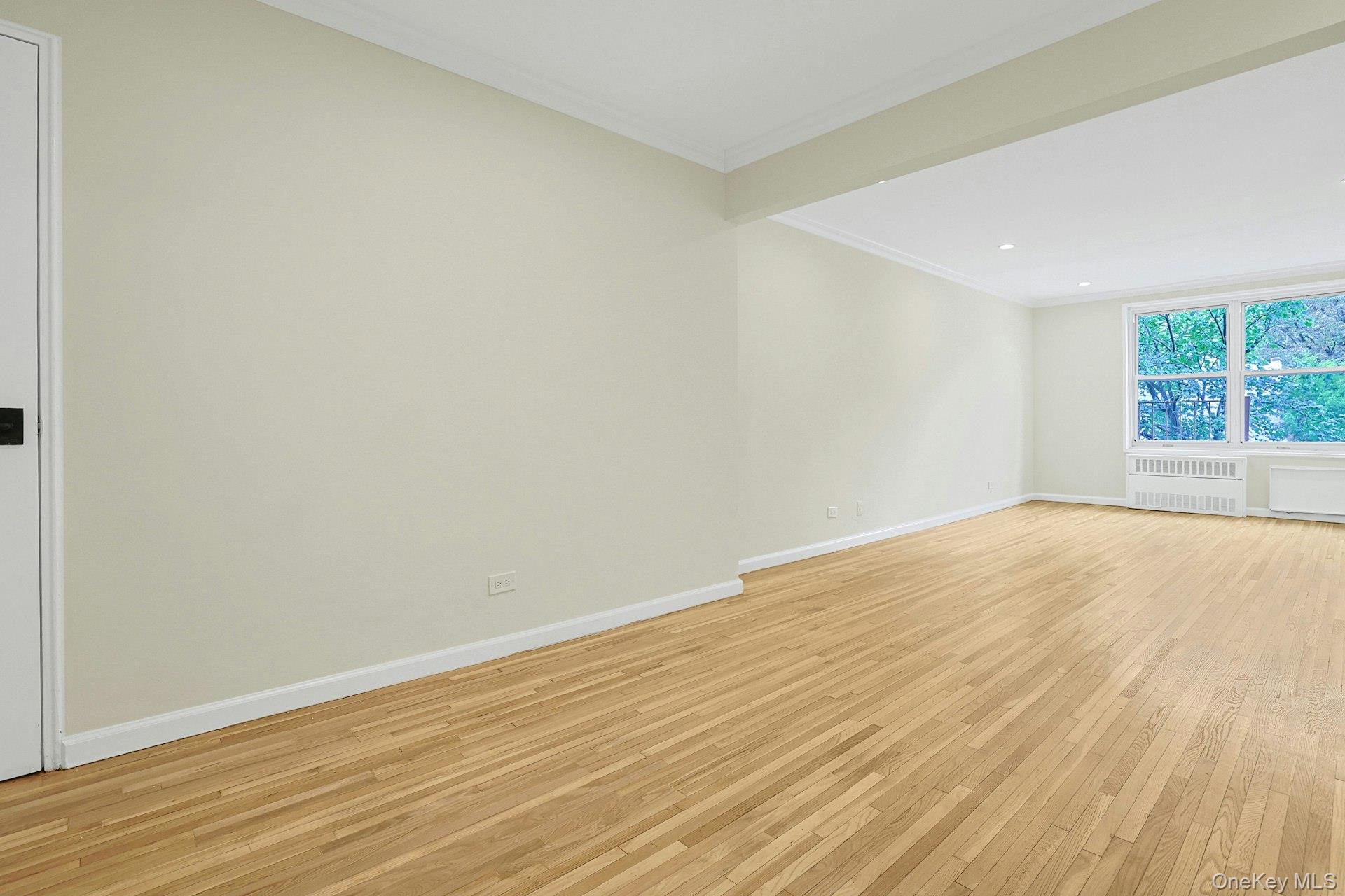3363 Sedgwick Avenue, Unit 4D Bronx, NY 10463 - Photo 15 of 23 an empty room with wooden floor and windows