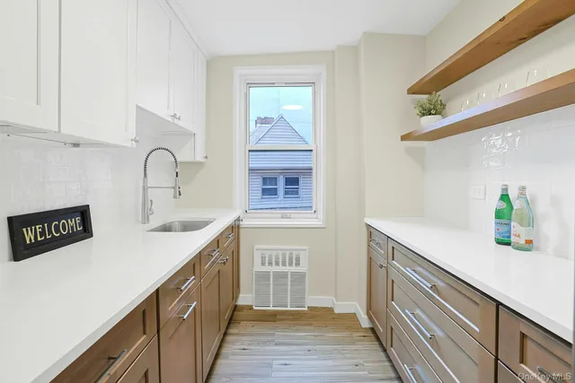 a kitchen with a sink a counter space and cabinets