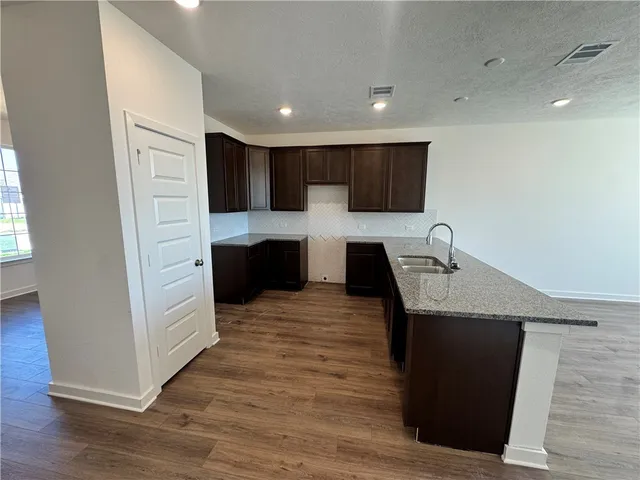 a view of kitchen with stainless steel appliances granite countertop stove top oven and refrigerator
