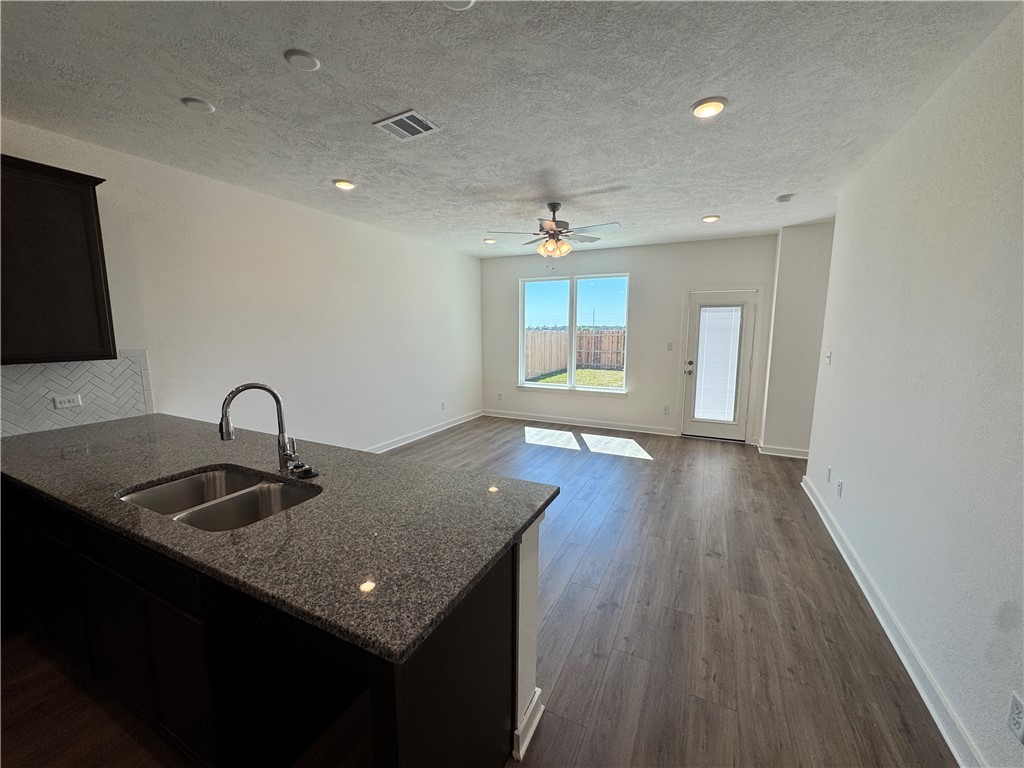 2425 Rooke Road Bryan, TX 77807 - Photo 10 of 10 a view of a kitchen island a sink wooden floor and a living room