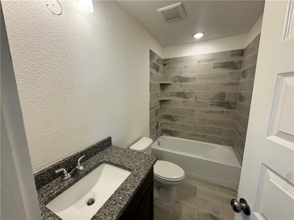 2425 Rooke Road Bryan, TX 77807 - Photo 4 of 10 a bathroom with a granite countertop sink a toilet a bathtub and shower