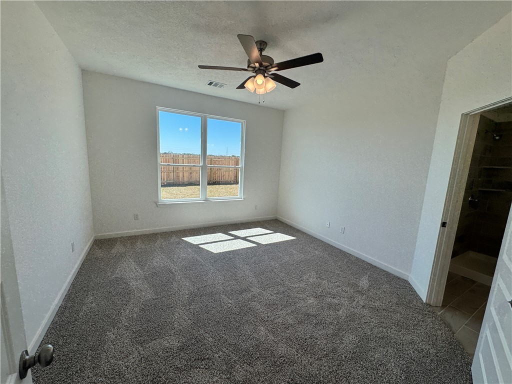 2425 Rooke Road Bryan, TX 77807 - Photo 7 of 10 an empty room with a window and a ceiling fan