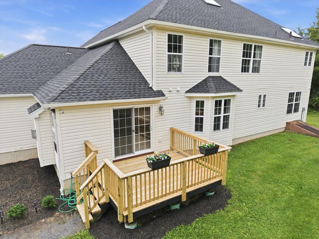 387 Blue Ridge Road Saylorsburg, PA 18353 - Photo 84 of 90 A newly constructed wooden deck extends from a home with light-colored siding and a dark shingle roof.