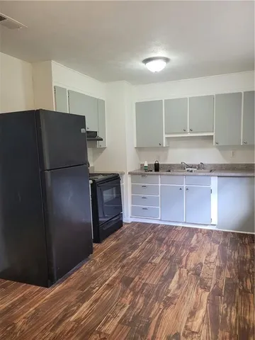 a kitchen with granite countertop a refrigerator and a sink