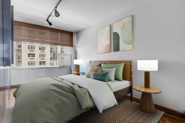 a bedroom with a bed lamps and a window