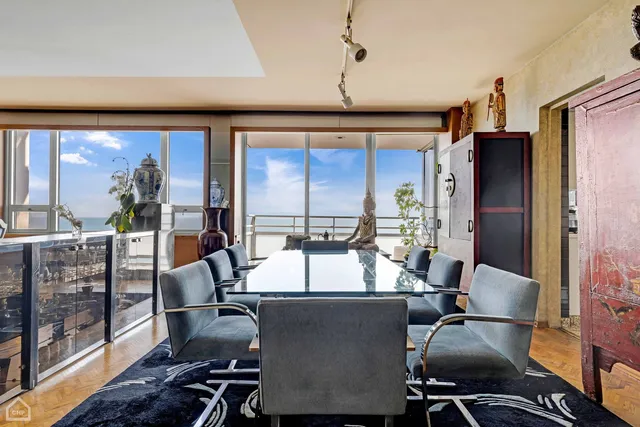 a view of a dining room with furniture a chandelier and wooden floor