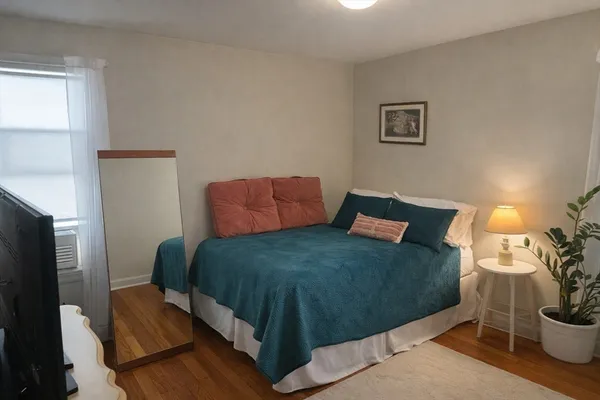 a bedroom with a bed and a potted plant
