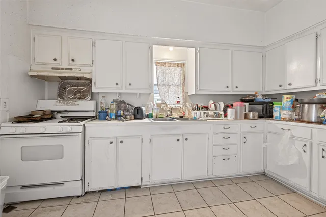 a kitchen with granite countertop white cabinets and white appliances