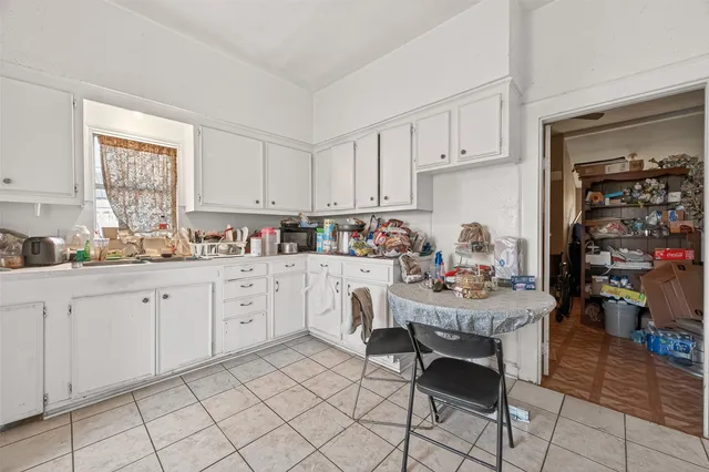 a kitchen with white cabinets and stove top oven
