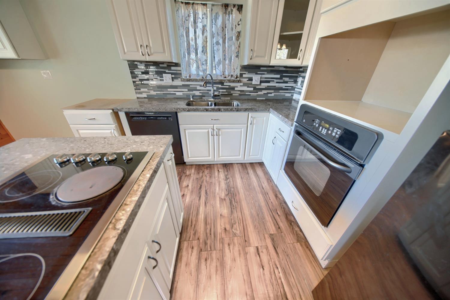 30000 Kasson Road Tracy, CA 95304 - Photo 32 of 71 a kitchen with a stove a sink and a microwave