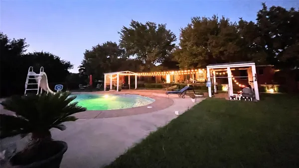 a view of a house with swimming pool and yard