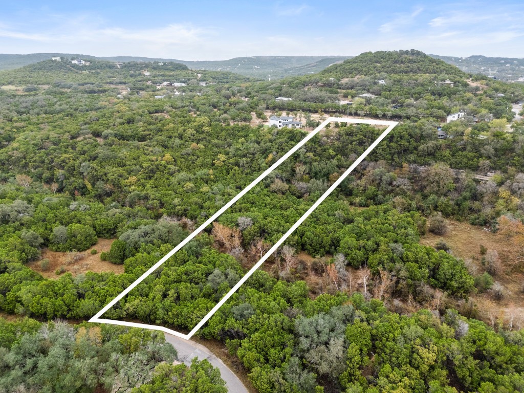 18211 Gregg Bluff Road Jonestown, TX 78645 - Photo 18 of 24 Aerial view of property and surrounding area with property boundaries highlighted and a mountainous background