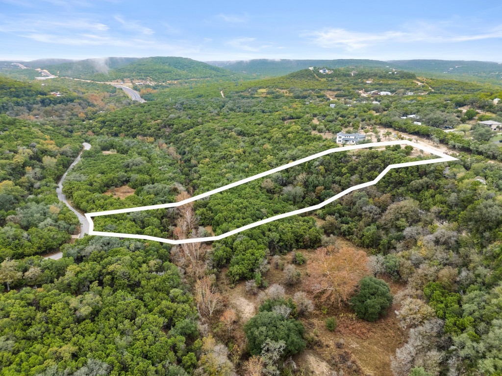 18211 Gregg Bluff Road Jonestown, TX 78645 - Photo 4 of 24 Aerial overview of property's location with property boundaries highlighted and a mountainous background