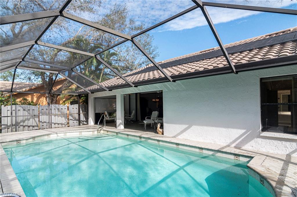 249 St James Way Naples, FL 34104 - Photo 19 of 23 a view of a backyard with table and chairs
