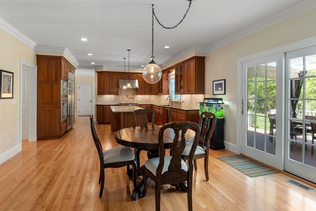 30 Pinecroft Road Weston, MA 02493 - Photo 12 of 38 a dining room with stainless steel appliances granite countertop a dining table chairs and a refrigerator