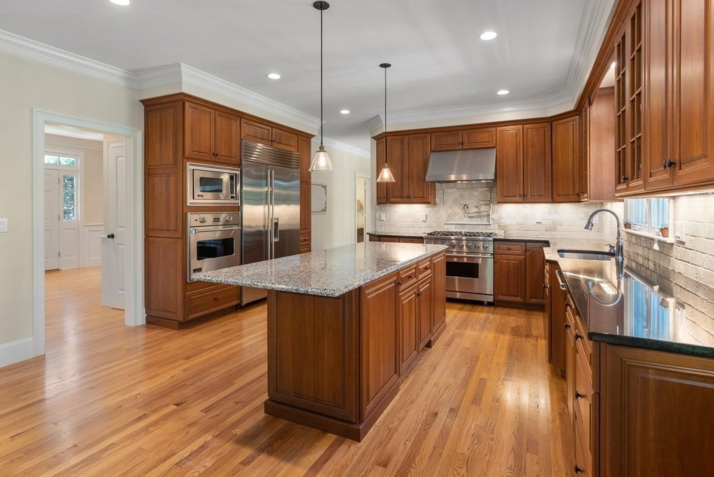 30 Pinecroft Road Weston, MA 02493 - Photo 14 of 38 a kitchen with stainless steel appliances granite countertop wooden floors and view of living room